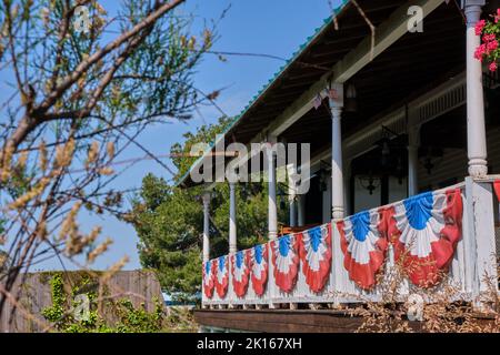 Profuse American patriotic decorations with flags bunting  and garlands in the nation's colors on the balconies of southern mansions Stock Photo