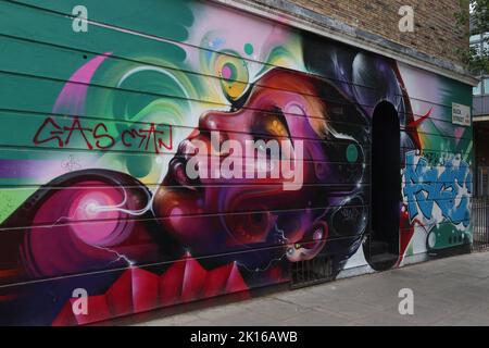 Graffiti art spray can painting of a beautiful African woman, Buck St, Camden, London, NW1 8NJ Stock Photo