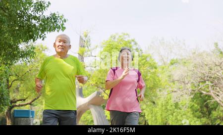 happy senior asian couple exercising and  running in the park Stock Photo