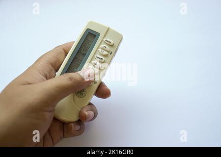 human hand on used remote air conditioner until it turns yellow isolated on white Stock Photo