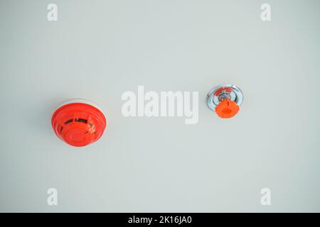 New Fire Sprinkler and Smoke sensor detector mounted on roof in home or apartment Stock Photo