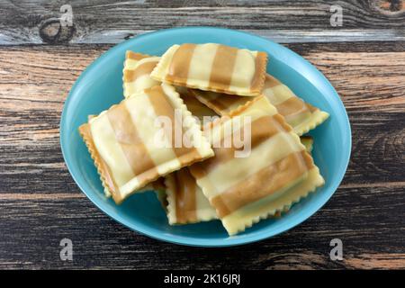 Uncooked portabello mushroom and fontina cheese ravioli pasta in ingredient bowl Stock Photo