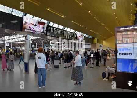 Passengers waiting for trains watching the departure boards at Queen Street Station, Glasgow, Scotland, UK Stock Photo