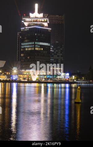 Amsterdam bei Nacht - Stunning architecture with colorful reflections on the waterfront during nighttime. Stock Photo