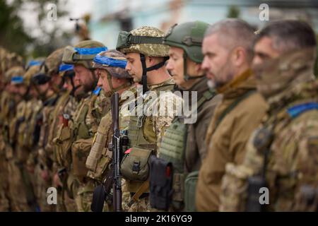 September 14, 2022, Izyum, Kharkiv region, Ukraine: Ukrainian soldiers at the flag raising ceremony. Ukrainian President Zelenskyy has paid a surprise visit to Izyum in Kharkiv region after the city was recaptured from Russian forces. (Credit Image: © Ukraine Presidential Press Service/ZUMA Press Wire) Stock Photo