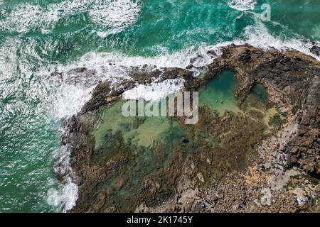 Arial drone shot of the Champagne Pools on Fraser Island (K'gari) in Queensland, Australia. The beautiful water is crashing against the rocks below. Stock Photo