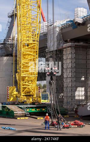 mounting a traverse for heavy load on a crane hook on the construction site of the new river Rhine bridge of the Autobahn A1 between Cologne and Lever Stock Photo