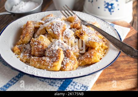 Traditional austrian kaiserschmarrn with powdered sugar on a enamel plate Stock Photo