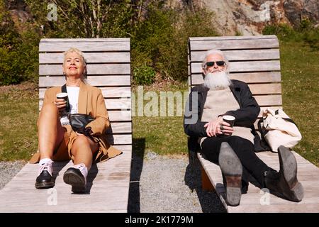 Couple relaxing on sun loungers Stock Photo