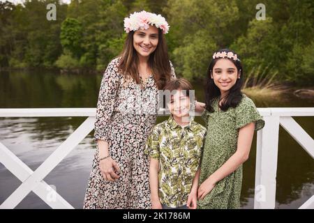 Mother with children standing at lake Stock Photo