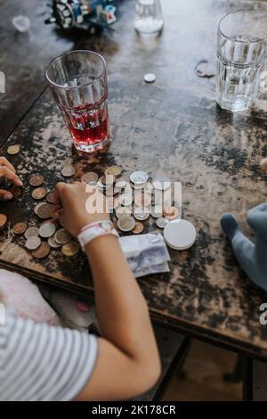 Child counting coins on table Stock Photo