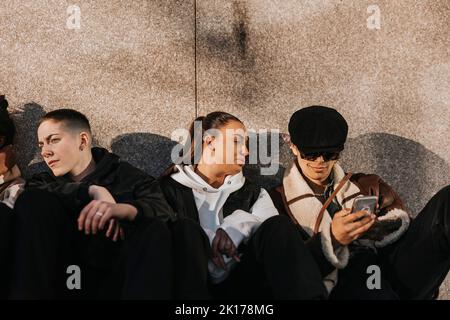 Young friends sitting together Stock Photo