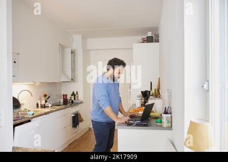 Man working on laptop from home Stock Photo