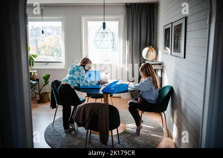 Girls sitting at table Stock Photo