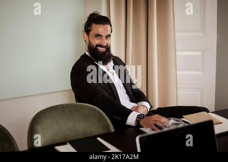 Smiling man sitting in boardroom Stock Photo