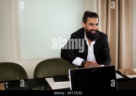 Smiling man sitting in boardroom Stock Photo