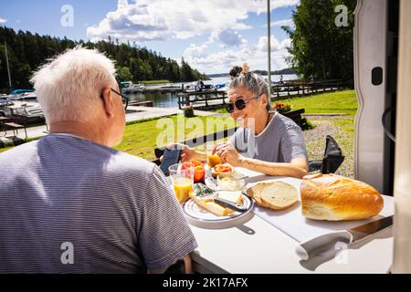 Senior couple having breakfast at camping Stock Photo