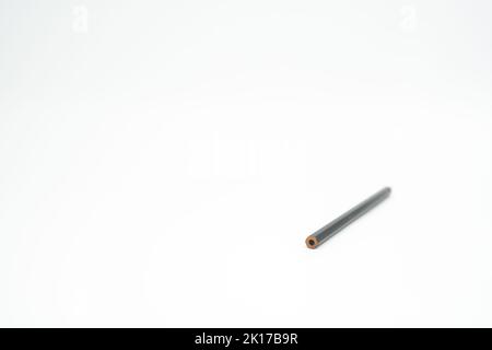 Black wooden colored pencil on a white background with end part in focus Stock Photo