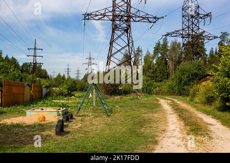 High-voltage power line passing over summer cottages Stock Photo