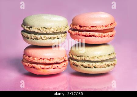 Stack of tasty french macarons on a pink pastel background. Stock Photo