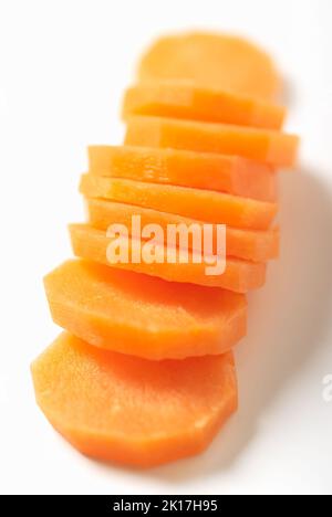 A close-up of a raw carrot sliced on white background vertical Stock Photo