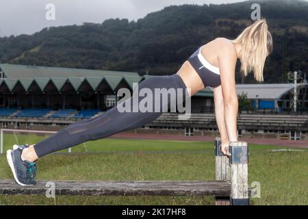 sport and lifestyle concept - woman doing sports outdoors. Young woman doing push-ups Stock Photo