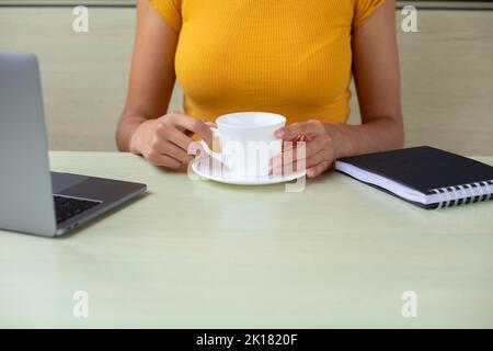 Crop freelancer enjoying hot drink in cafe Stock Photo