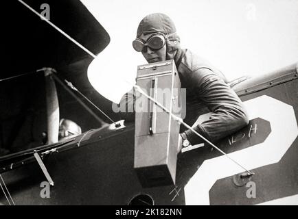 An aerial photographer with a Graflex Model A erial camera, ca. 1917-18. The large leather covered wood bodied camera was one of the pioneering aerial cameras, widely used by the US Army Air Corps. Fired by a pistol type trigger, the focal plane shutter fired as the two protective shutter blinds at the front of the camera opened. A 4x5' format with a Graflex back meant standard double sided plate holders could be used as well as a 12 plate 'bag mag' magazine. Stock Photo