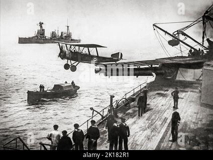 A Sopwith 1 1/2 Strutter biplane aircraft taking off, in 1918 from a platform built on top of the midships “Q” turret on HMAS 'Australia', an Indefatigable-class battlecruisers. The Sopwith 1+1⁄2 Strutter was a British single- or two-seat multi-role biplane aircraft of the First World War It was the first British two-seat tractor fighter and the first British aircraft to enter service with a synchronised machine gun. Stock Photo