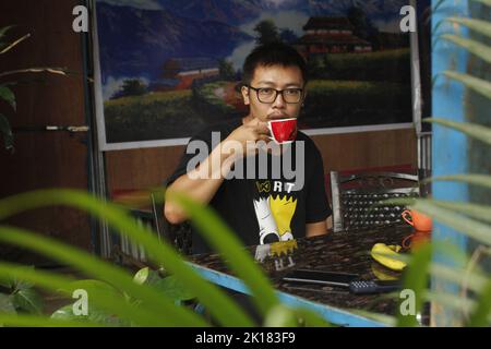 A Handsome yong man is drinking tea , drinking tea and eating fruit Stock Photo