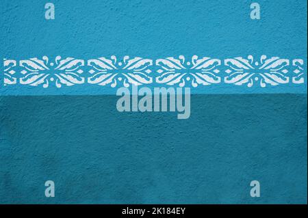 White key pattern painted on bright blue wall of building on town street Stock Photo