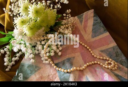 Faded  Union jack  with  lily  of the  valley  and  pearls  for Queen Elizabeth II death Stock Photo
