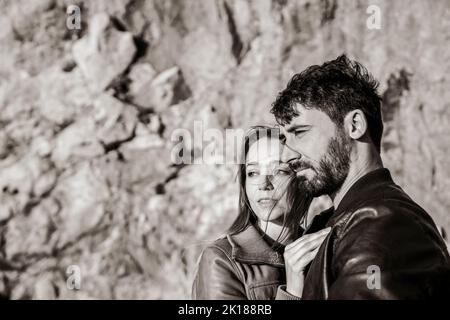 Couple of travelers looking far away at sunset against a beautiful ...