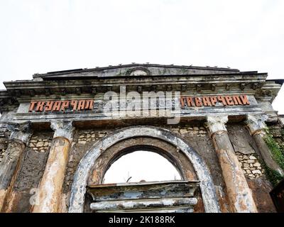 The building of an abandoned railway station with an arched window against a cloudy sky Stock Photo