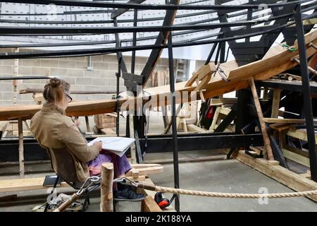 Woodbridge, Suffolk, UK - 16 September 2022 ; The Longshed boat building project at Whisstocks Square. Artist at work sketching. Stock Photo