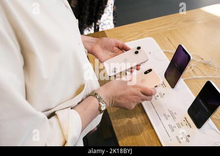 Paris, France - 9 Sep 2022: Side view of woman hands comparing the latest Apple Computers iphone 12 Pro with her XS version camera options two lens camera vs old version of the photographic equipment Stock Photo