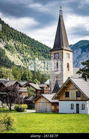 View of a typical house in the center of Altaussee, Ausseer Land Region, Styria, Austria, with the Catholic church of Altaussee in the background Stock Photo