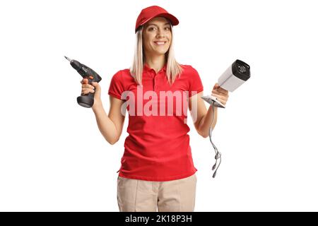 Female technician holding a surveillance camera and a drill machine isolated on white background Stock Photo