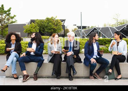 Multiracial business people with different ages having a lunch break outside office Stock Photo