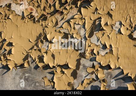 Metal background with cracked paint. The texture of the exfoliating paint of the paint. Background of old painted metal. Peeling paint on metal. Stock Photo