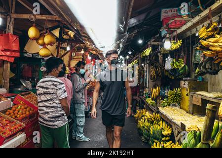 young man walking through the street fruit market of Glodok Chinatown in Jakarta Indonesia Stock Photo