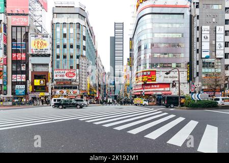 Shinjuku, Tokyo Japan - January 17 2020: Pedestrian crosswalk on busy road in Kabukicho during a cloudy winter day Stock Photo