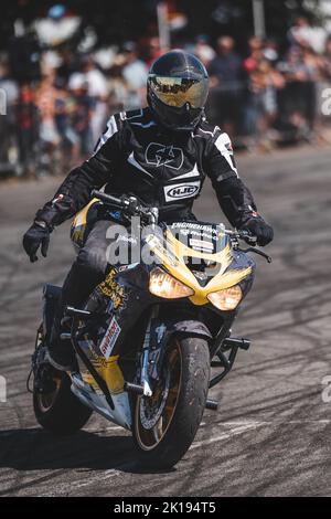 A closeup shot of a man on a Motorbike in full leathers and a helmet Stock Photo