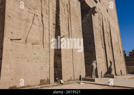 View to the main entrance of an Ancient Egyptian Edfu Temple showing the first pylon in the Sunny Day, Egypt Stock Photo