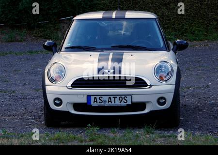Rheine, NRW, Germany - August 24 2022Front view of a white mini cooper with black custom rally stripes. Judging by the grill and headlights, this car Stock Photo