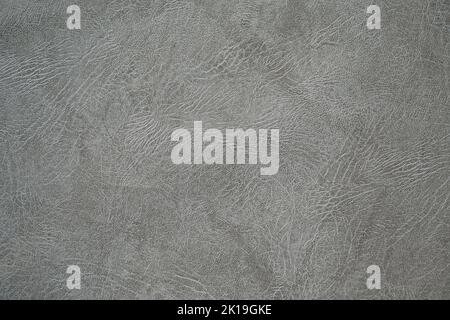 The texture of artificial leather. Background of black leather with patterns. Artificial material made of gray leather. Stock Photo