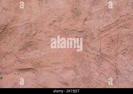 The texture of old painted concrete. The concrete background is dusty pink. The background of a painted wall with cracks. Stock Photo