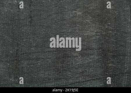 Background of a black awning in close-up. The texture of an old worn tarpaulin. The tent tarpaulin damaged in nature Stock Photo