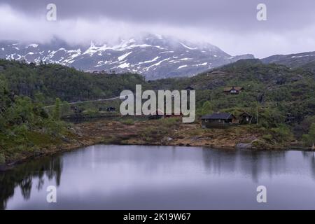 Wonderful landscapes in Norway. Vestland. Beautiful scenery of houses with grass roof. Norwegian traditional architecture Mountains, trees and snow in Stock Photo