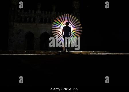 Kodanadu, Tamilnadu, India - March 14 2021 : one person standing against beautiful colorful circle light painting as the backdrop. light painting port Stock Photo